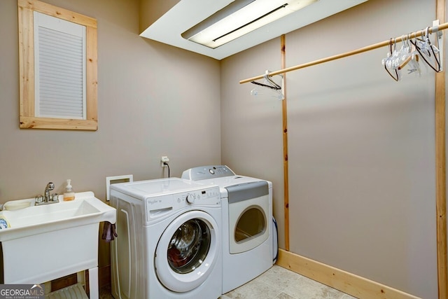 clothes washing area featuring separate washer and dryer and sink