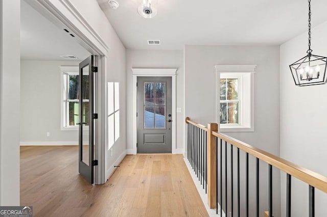 foyer entrance with a chandelier and light hardwood / wood-style flooring