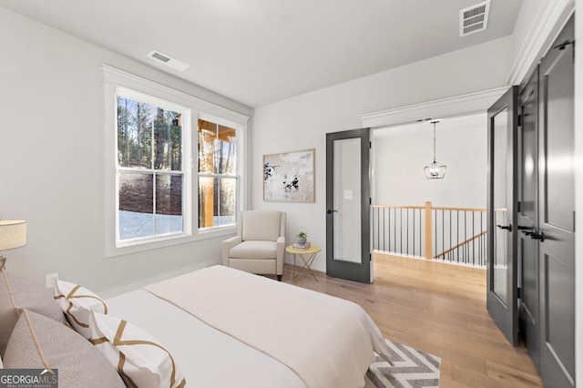 bedroom featuring french doors and light hardwood / wood-style flooring