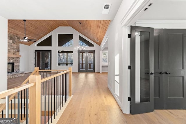 corridor with light wood-type flooring, wood ceiling, and an inviting chandelier