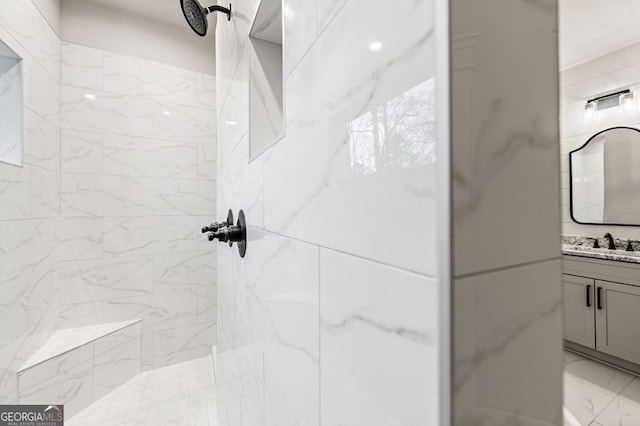 bathroom with vanity and tiled shower