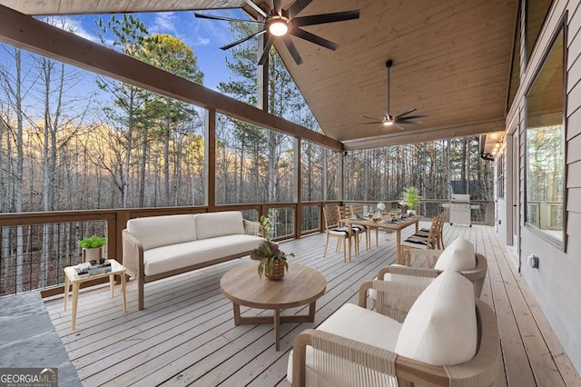 wooden deck featuring ceiling fan, an outdoor hangout area, and an outdoor kitchen