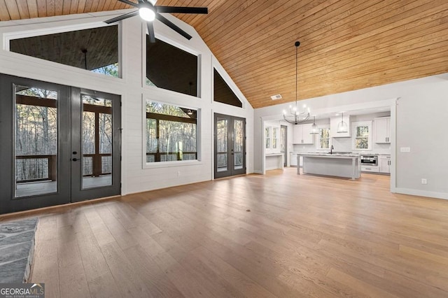 unfurnished living room featuring high vaulted ceiling, french doors, wood ceiling, and light hardwood / wood-style flooring