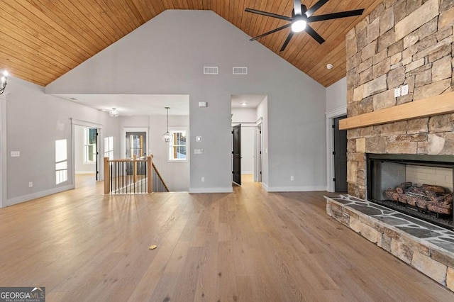 unfurnished living room featuring ceiling fan, wood ceiling, a fireplace, and light hardwood / wood-style flooring