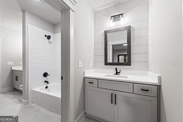 bathroom with tiled shower / bath and vanity