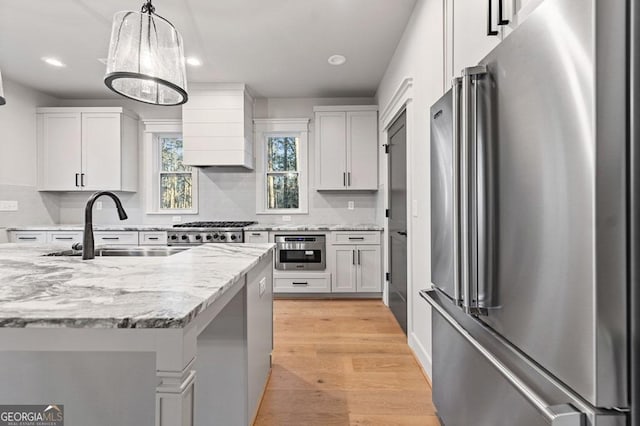 kitchen featuring premium range hood, white cabinets, and appliances with stainless steel finishes