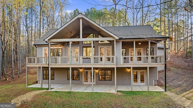 rear view of property with ceiling fan, a yard, french doors, and a patio