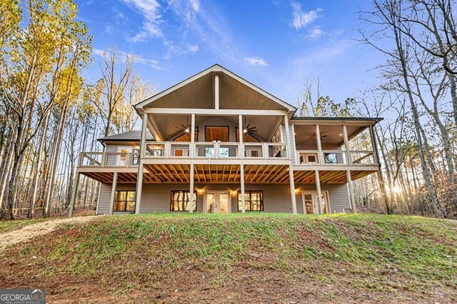 back of property featuring ceiling fan and a wooden deck