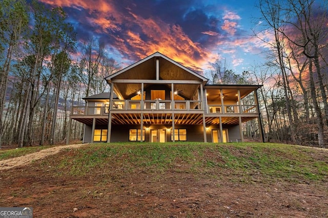 back house at dusk featuring ceiling fan