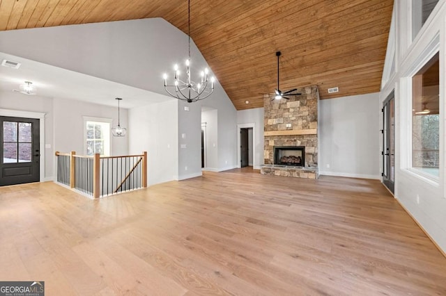 unfurnished living room featuring wood ceiling, light hardwood / wood-style floors, a fireplace, high vaulted ceiling, and ceiling fan with notable chandelier