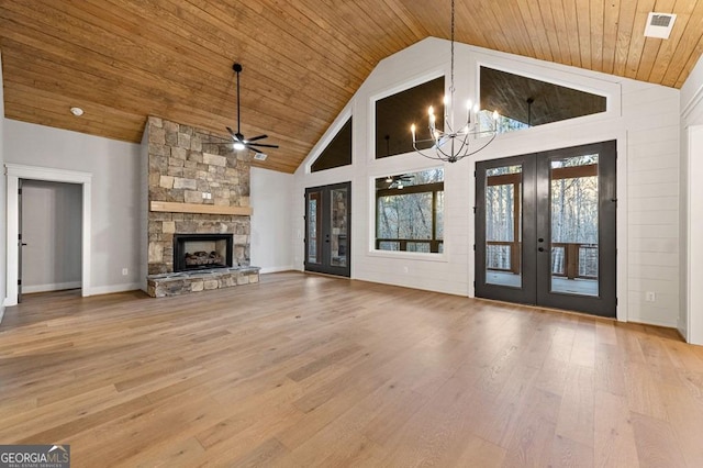 unfurnished living room with high vaulted ceiling, hardwood / wood-style floors, french doors, and a fireplace