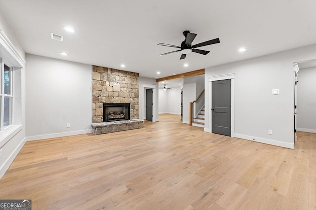 unfurnished living room with light wood-type flooring, ceiling fan, and a fireplace