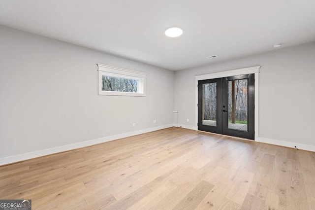 empty room featuring french doors and light wood-type flooring