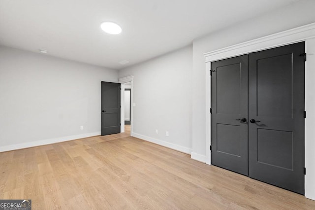 unfurnished bedroom with a closet and light hardwood / wood-style flooring