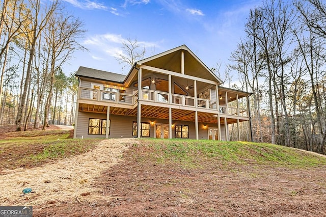 rear view of property featuring ceiling fan, a deck, and a sunroom