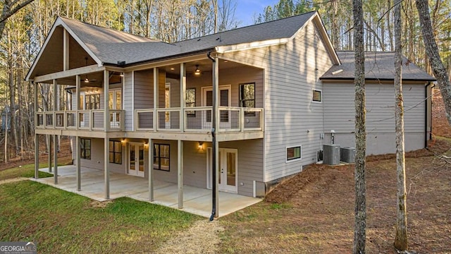 rear view of house with ceiling fan, a patio area, a yard, and a balcony