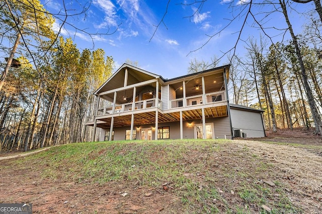 rear view of house with ceiling fan, a balcony, and central air condition unit