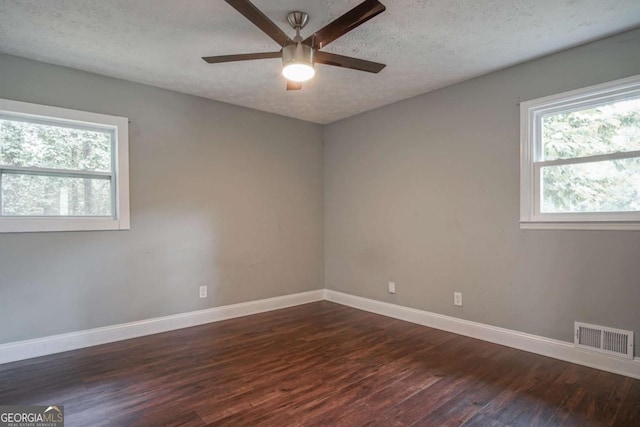 empty room featuring a textured ceiling, ceiling fan, and dark hardwood / wood-style flooring