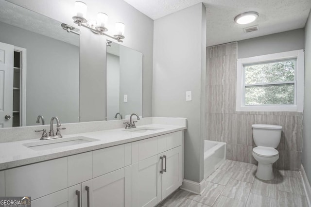 full bathroom with toilet, vanity, tile walls, and a textured ceiling