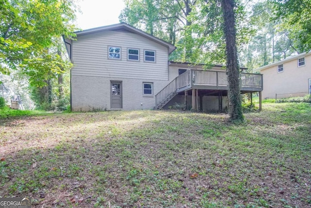 rear view of house with a wooden deck and a yard