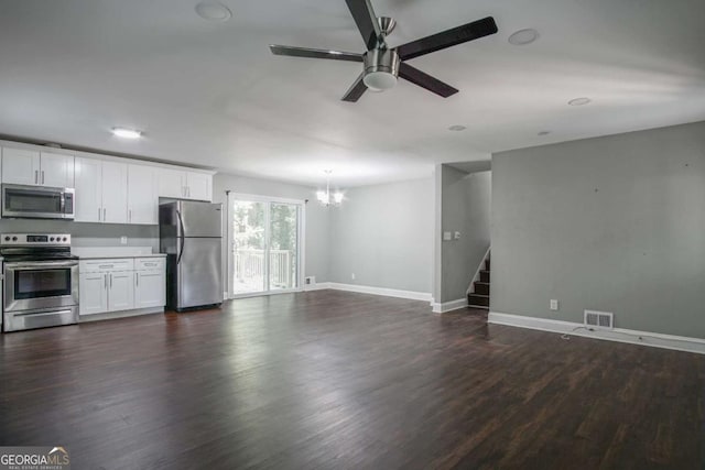 unfurnished living room with dark wood-type flooring and ceiling fan with notable chandelier