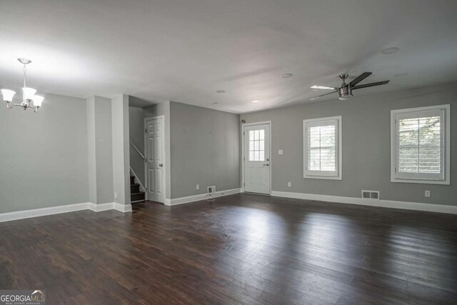 unfurnished room with ceiling fan with notable chandelier and dark hardwood / wood-style flooring