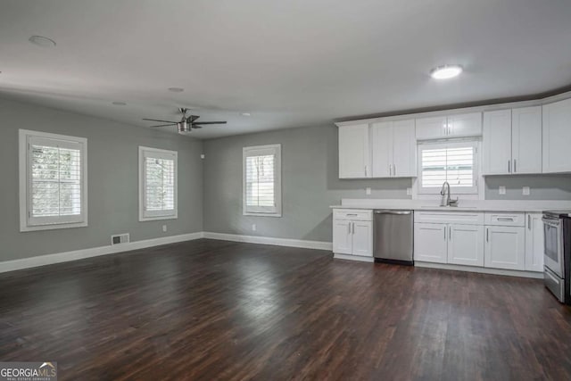 kitchen with stainless steel appliances, a healthy amount of sunlight, white cabinetry, and sink