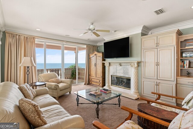 carpeted living room with ceiling fan, a high end fireplace, and crown molding
