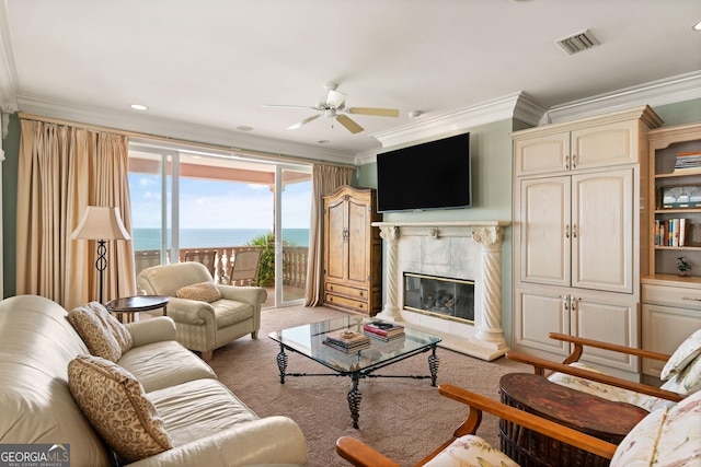 living room featuring a premium fireplace, carpet, ornamental molding, and ceiling fan