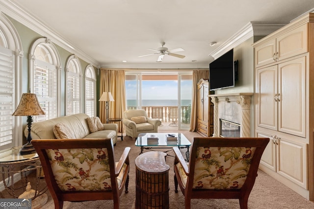 living room with ceiling fan, light colored carpet, a fireplace, and ornamental molding