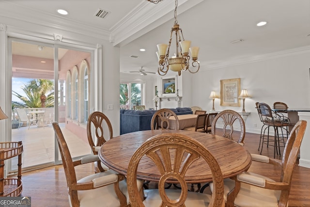 dining space featuring crown molding, ceiling fan with notable chandelier, and hardwood / wood-style floors