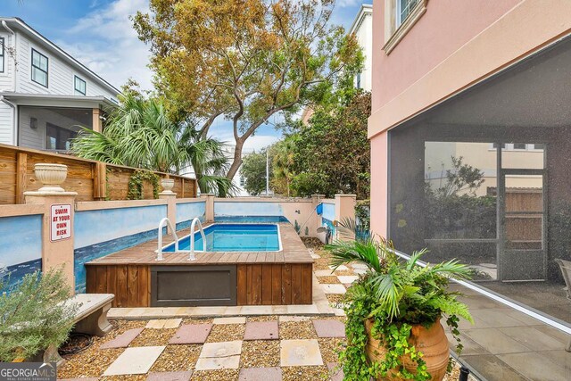 view of pool with a hot tub and a patio