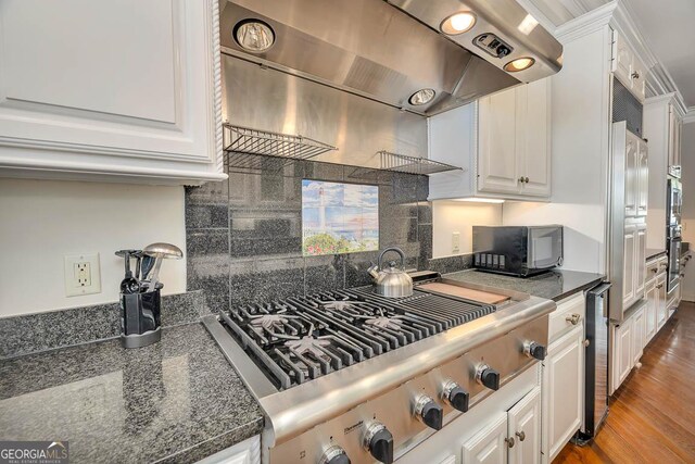 kitchen with hardwood / wood-style floors, beverage cooler, white cabinetry, island exhaust hood, and stainless steel gas stovetop