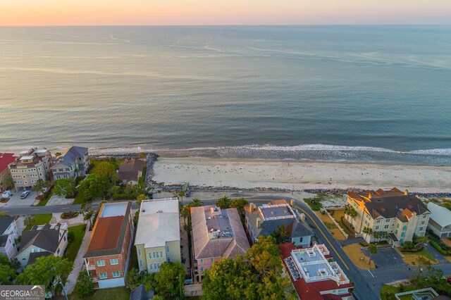 aerial view at dusk with a beach view and a water view