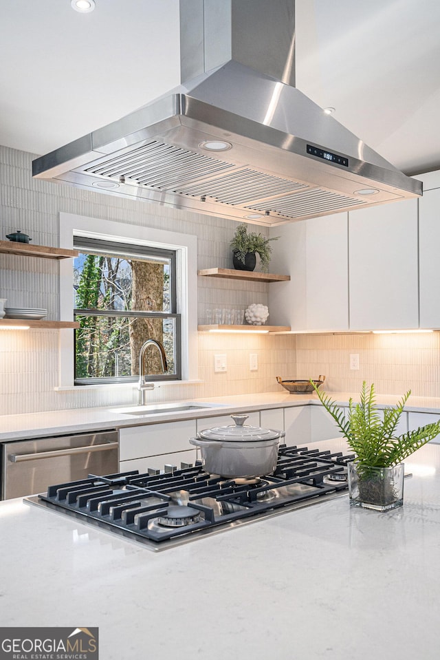 kitchen featuring white cabinetry, island exhaust hood, appliances with stainless steel finishes, and sink