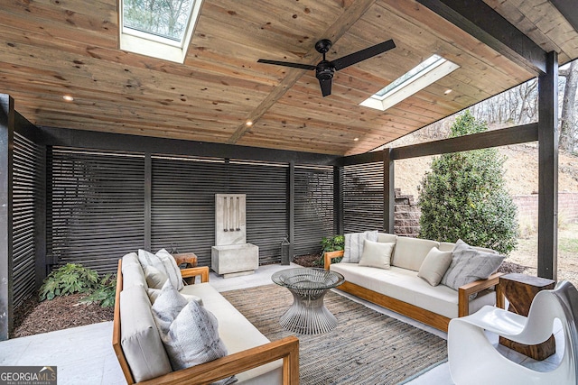 sunroom / solarium featuring ceiling fan, wooden ceiling, and vaulted ceiling with skylight