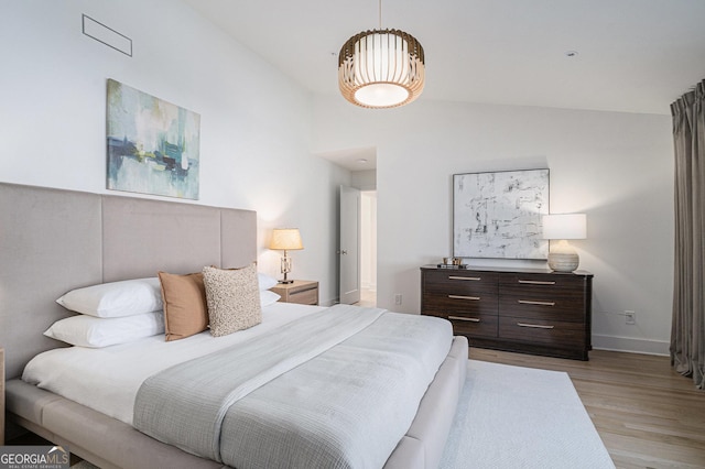 bedroom with light hardwood / wood-style flooring and vaulted ceiling