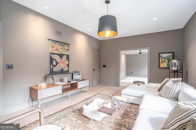 living room with ceiling fan and light hardwood / wood-style floors