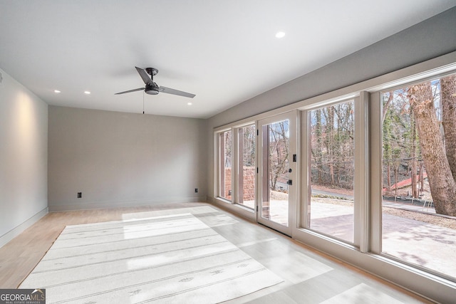 empty room with ceiling fan and light wood-type flooring