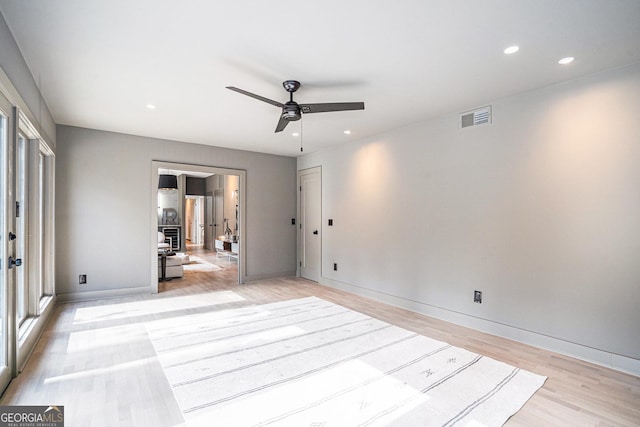 unfurnished room with ceiling fan, a wealth of natural light, and light wood-type flooring