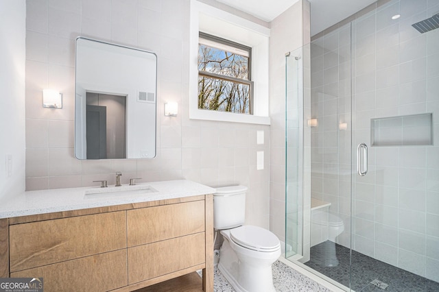 bathroom with vanity, tile walls, an enclosed shower, and toilet