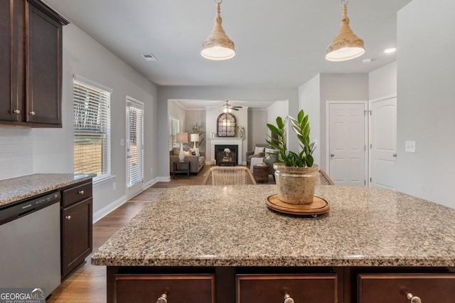 kitchen featuring pendant lighting, stainless steel dishwasher, and a center island