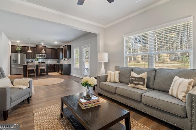 living room featuring ceiling fan, ornamental molding, a healthy amount of sunlight, and hardwood / wood-style floors