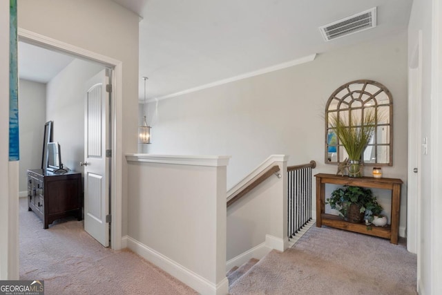 hallway with light carpet and crown molding