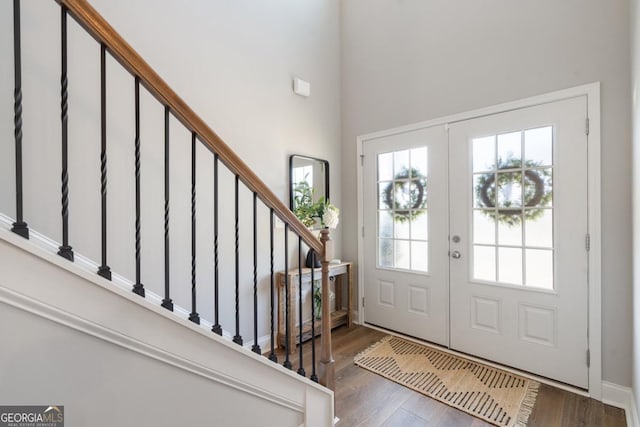 entryway with a high ceiling, dark wood-type flooring, and french doors