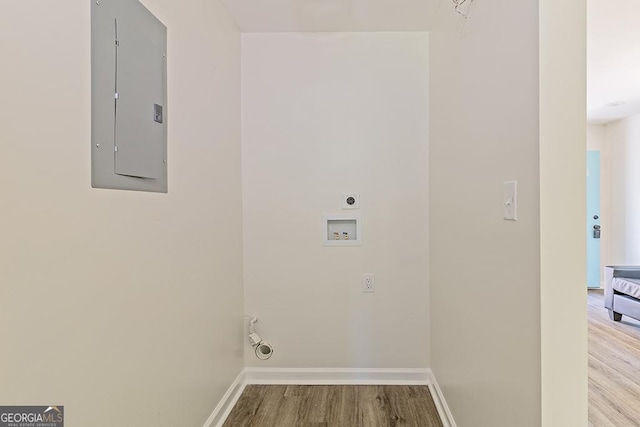 clothes washing area with light wood-type flooring, electric panel, hookup for a washing machine, and electric dryer hookup