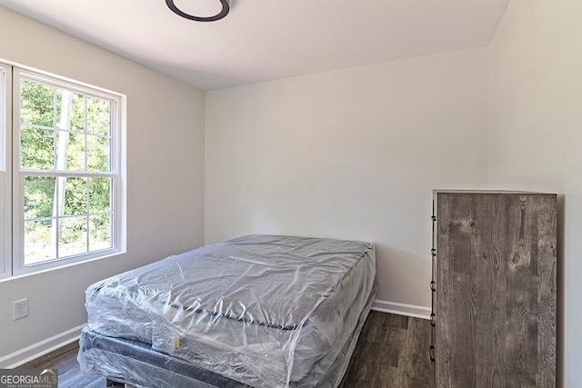 bedroom with dark hardwood / wood-style floors