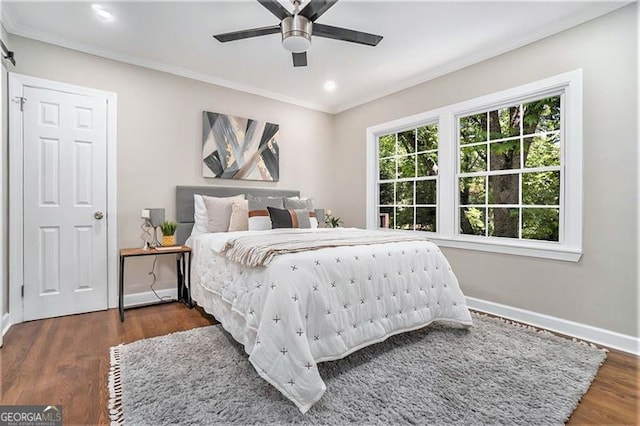 bedroom featuring ceiling fan, dark hardwood / wood-style floors, and crown molding