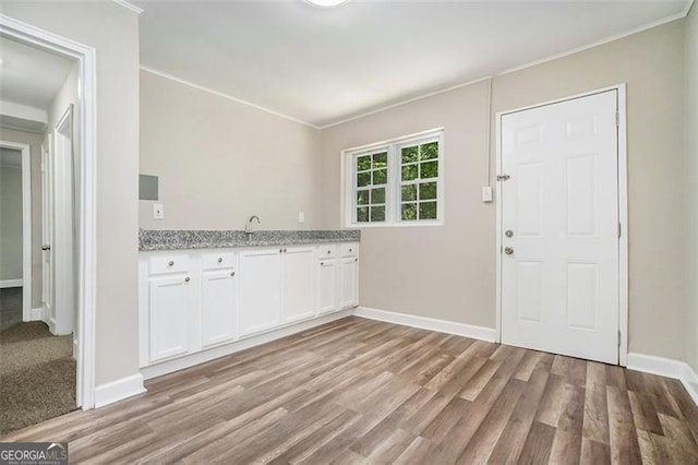 kitchen with light hardwood / wood-style flooring, white cabinets, and light stone countertops