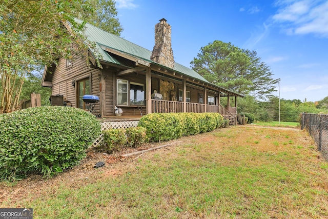 view of property exterior with covered porch and a lawn